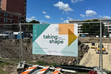 Sign at construction site reading "taking shape"